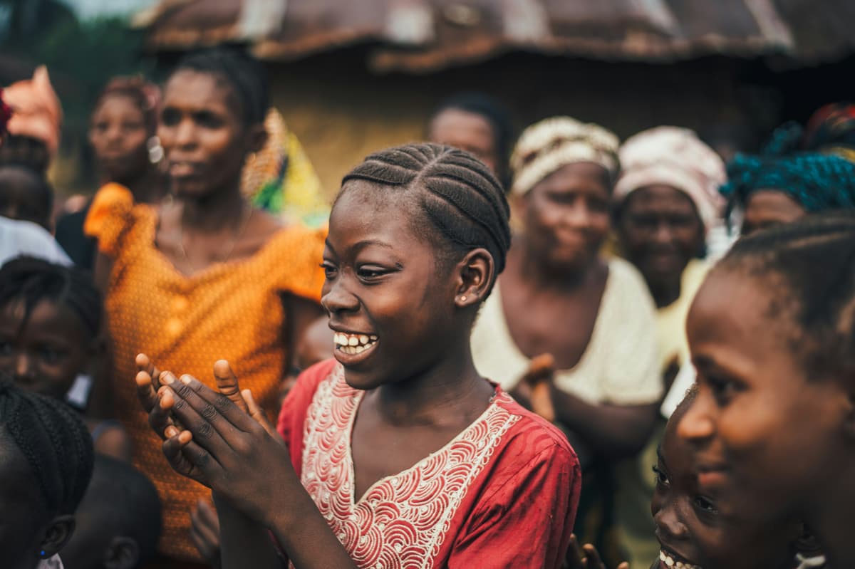 A group of young African women collaborating and smiling, symbolizing community and shared growth.